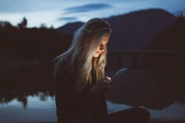 woman looking at phone screen at night